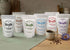 Assorted packages of Tecoffe Fusion coffee blends on a table with a mug and coffee beans.